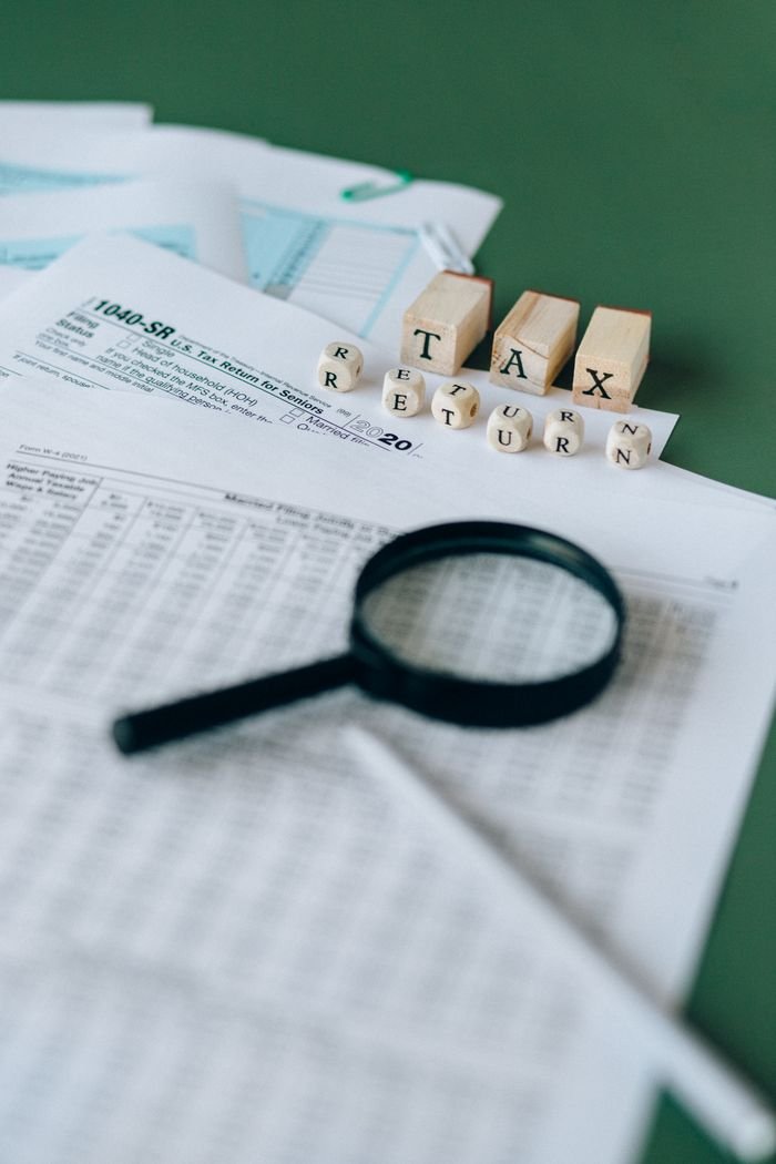 The Art of Drawing Readers In: Your attractive post title goes here Financial documents and magnifying glass highlight tax season analysis.