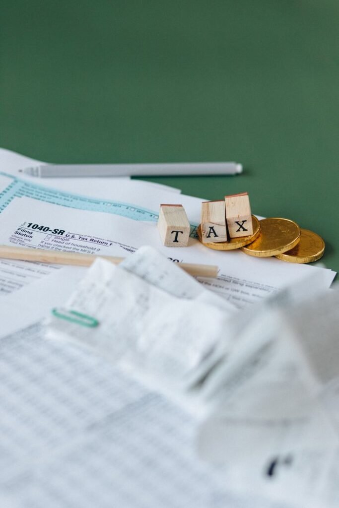 Crafting Captivating Headlines: Your awesome post title goes here Tax forms, coins, and block letters spelling 'TAX' on a green background, symbolizing finance.