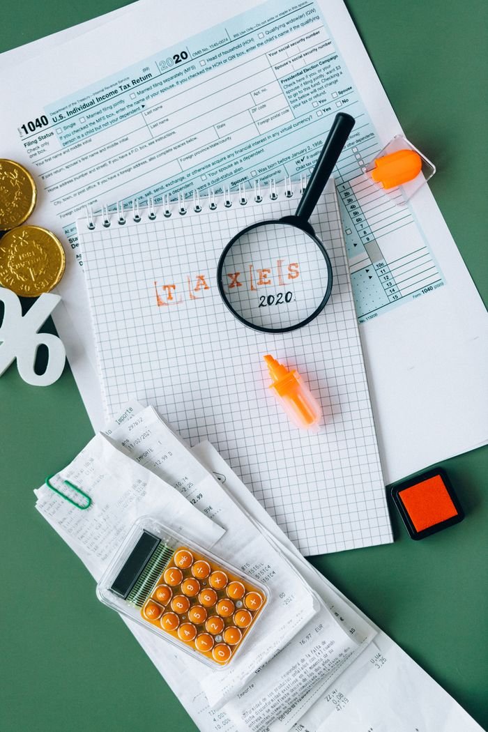 Top view of tax documents, calculator, and office supplies showcasing finance and accounting concepts.
